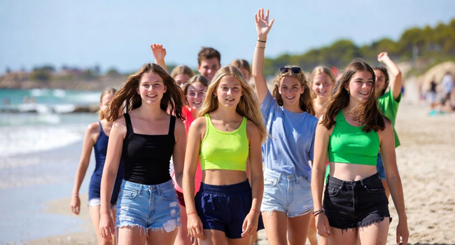 Sprachreise Mallorca Premium mit LISA! – Strand, Meer und gemeinsame Erlebnisse für Young Adults Young Adults am Strand in Mallorca während einer LISA! Sprachreise spazieren gemeinsam am Meer entlang und genießen die Freizeit