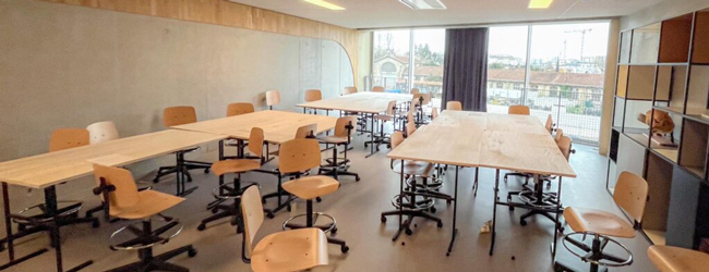 Ein Klassenraum mit Tischen und Stühlen und Blick aus dem Fenster der LISA! Sprachschule in Bordeaux