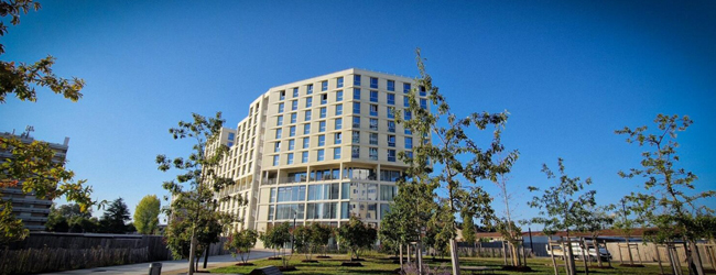 Blick auf das moderne Gebäude der LISA! Sprachschule in Bordeaux umgeben von Bäumen