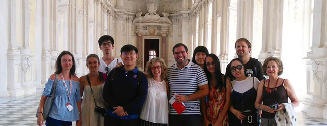 Mehrere Personen stehen für ein Gruppenfoto in der beeindruckenden Reggia di Venaria Reale während einer LISA! Sprachreise Italienisch in Turin