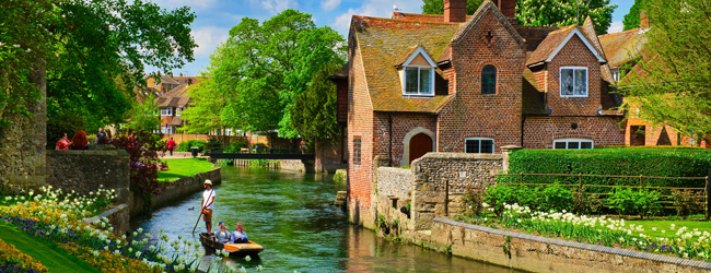 Idyllische britische Landschaft mit Fluss, Steinhaus und Garten im Sommer