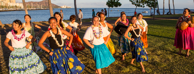 Mehrere Damen tanzen am Meer auf Hawaii in Röcken Hula bei einer LISA! Sprachreise in Honolulu