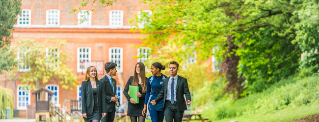 Schüler einer High School in England spazieren durch den Park der Schule