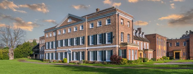 Gebäude einer High School in England im Abendsonnenschein mit Fensterläden