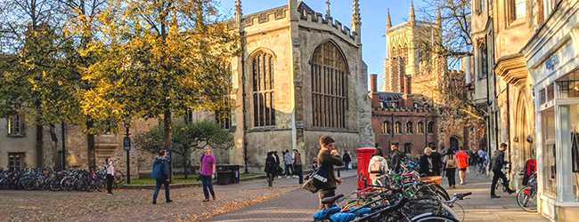Blick auf deine Strasse in Cambridge mit alten Gebäuden, Fahrrädern und vielen Studenten