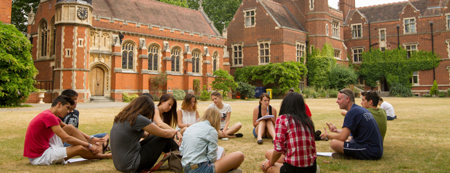 Jugendliche sitzen im Kreis auf dem Rasen vor dem Newnham College in Cambridge bei einem LISA! Sprachkurs