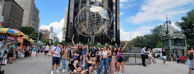 Eine Schülergruppe posiert vor Sehenswürdigkeiten in New York